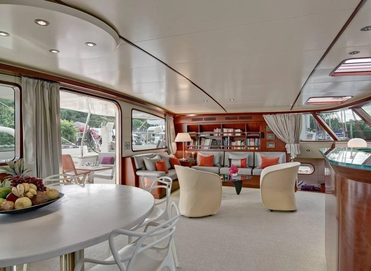 a room with a table chairs and a window with a view of the city aboard MIROVIA Yacht for Charter