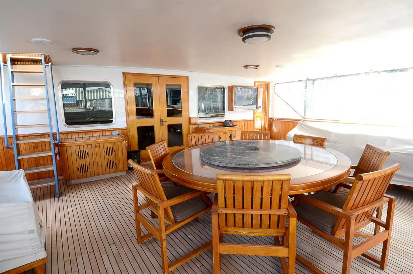 a dining table and chairs in a room with a large window aboard SHENANDOAH Yacht for Sale