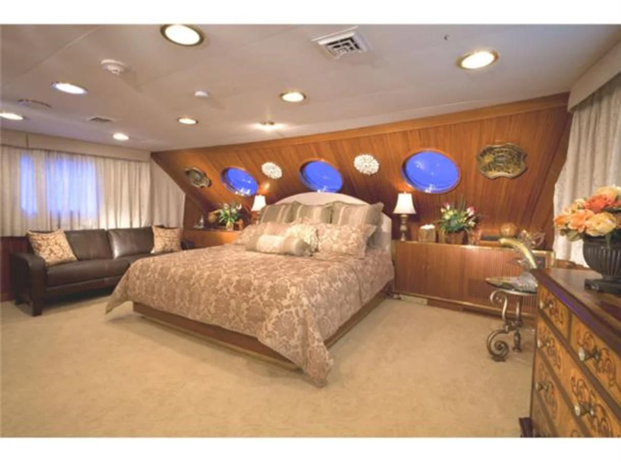 a bedroom with a bed and a chair aboard SHENANDOAH Yacht for Sale