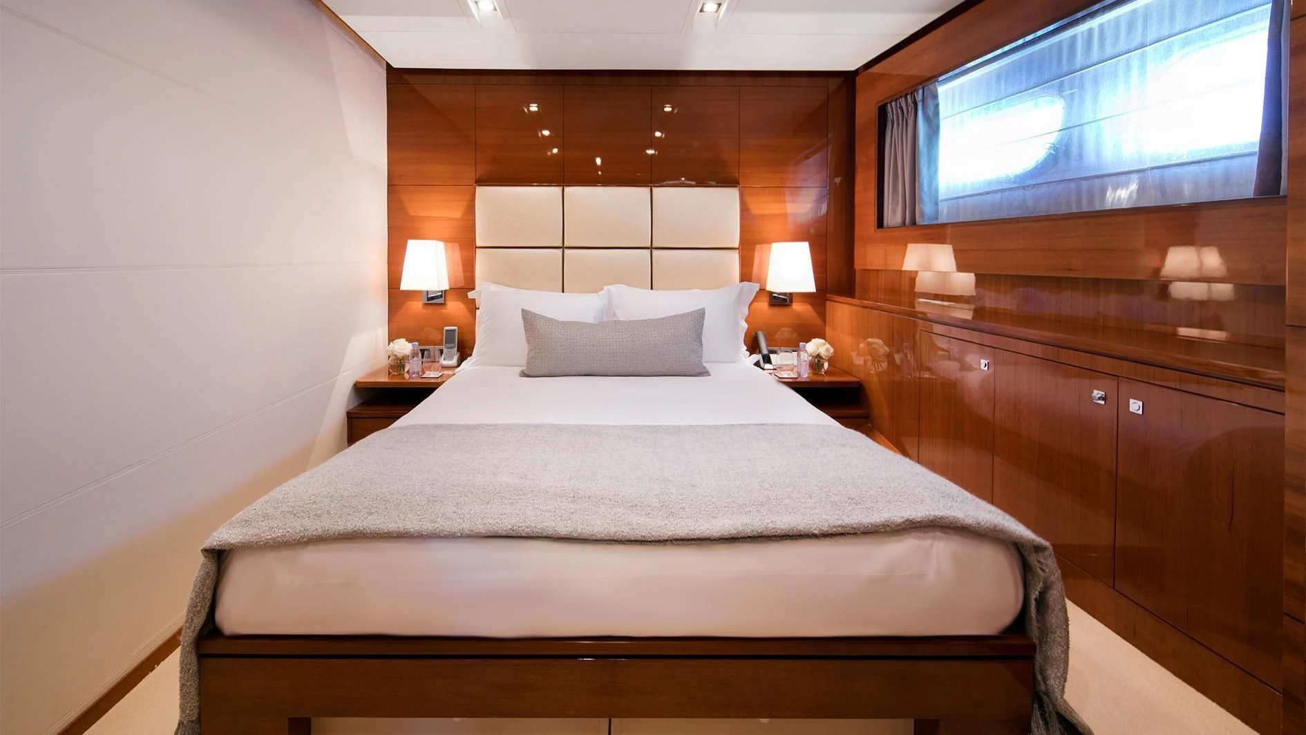 a bed with a white sheet and pillows aboard APMONIA Yacht for Sale