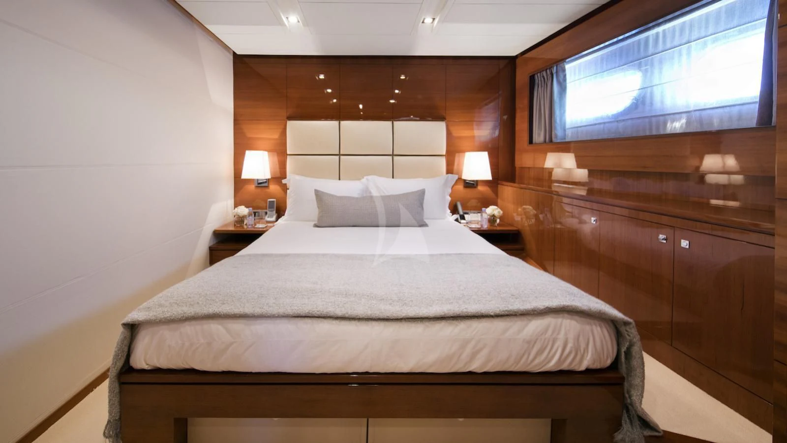 a bed with a white sheet and pillows aboard APMONIA Yacht for Sale