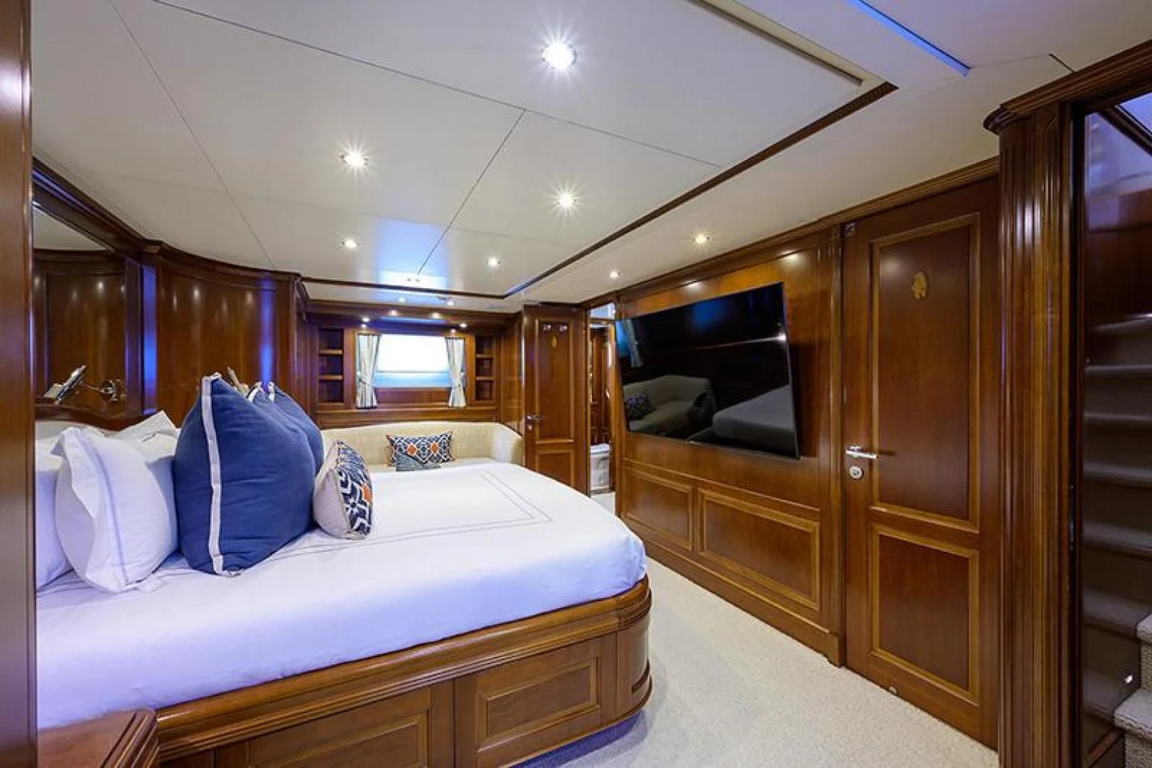 a bedroom with a bed and a wood cabinet aboard ARTEMIS Yacht for Sale