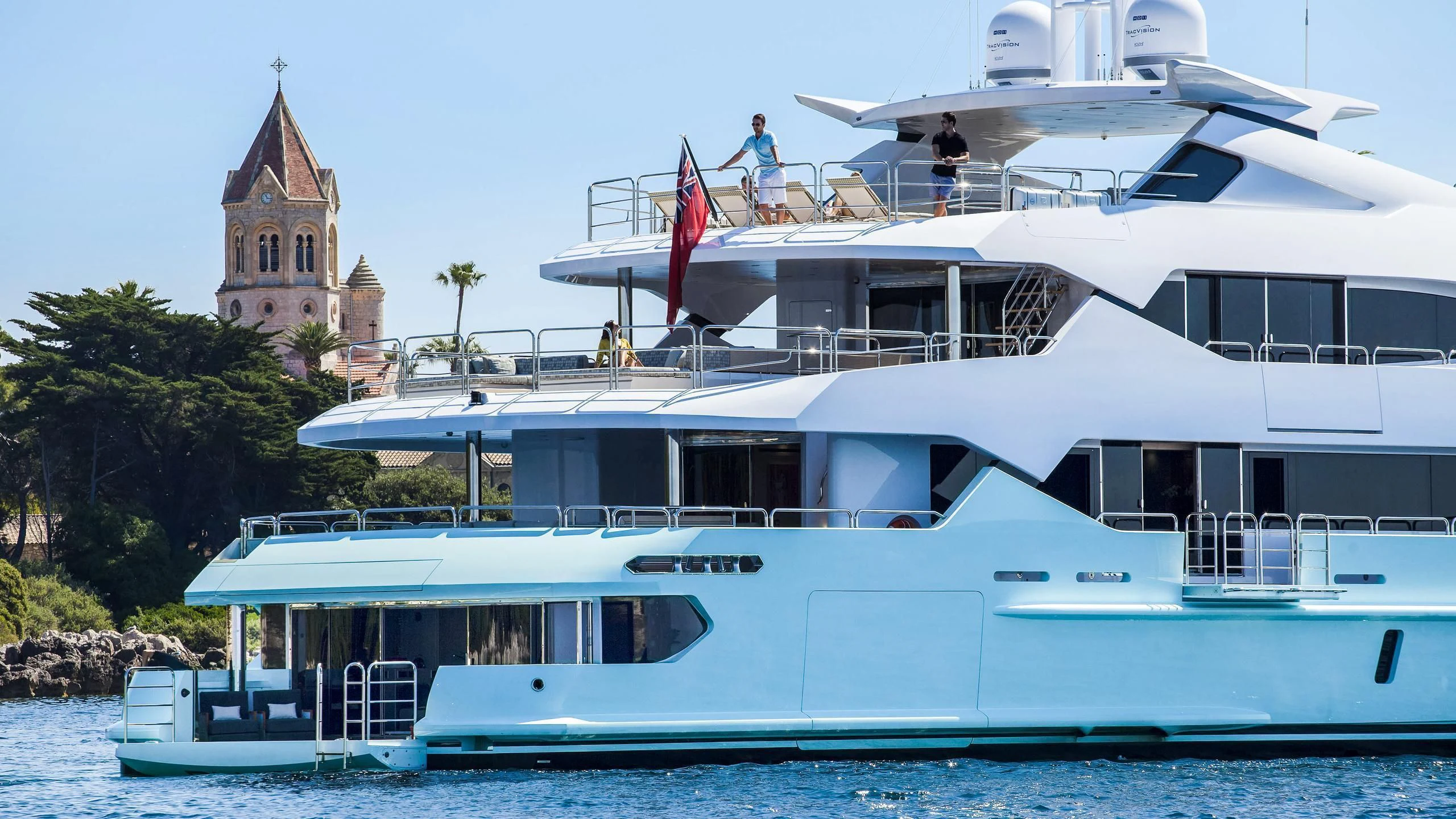 a large white boat with a flag on the front aboard ARADOS Yacht for Charter