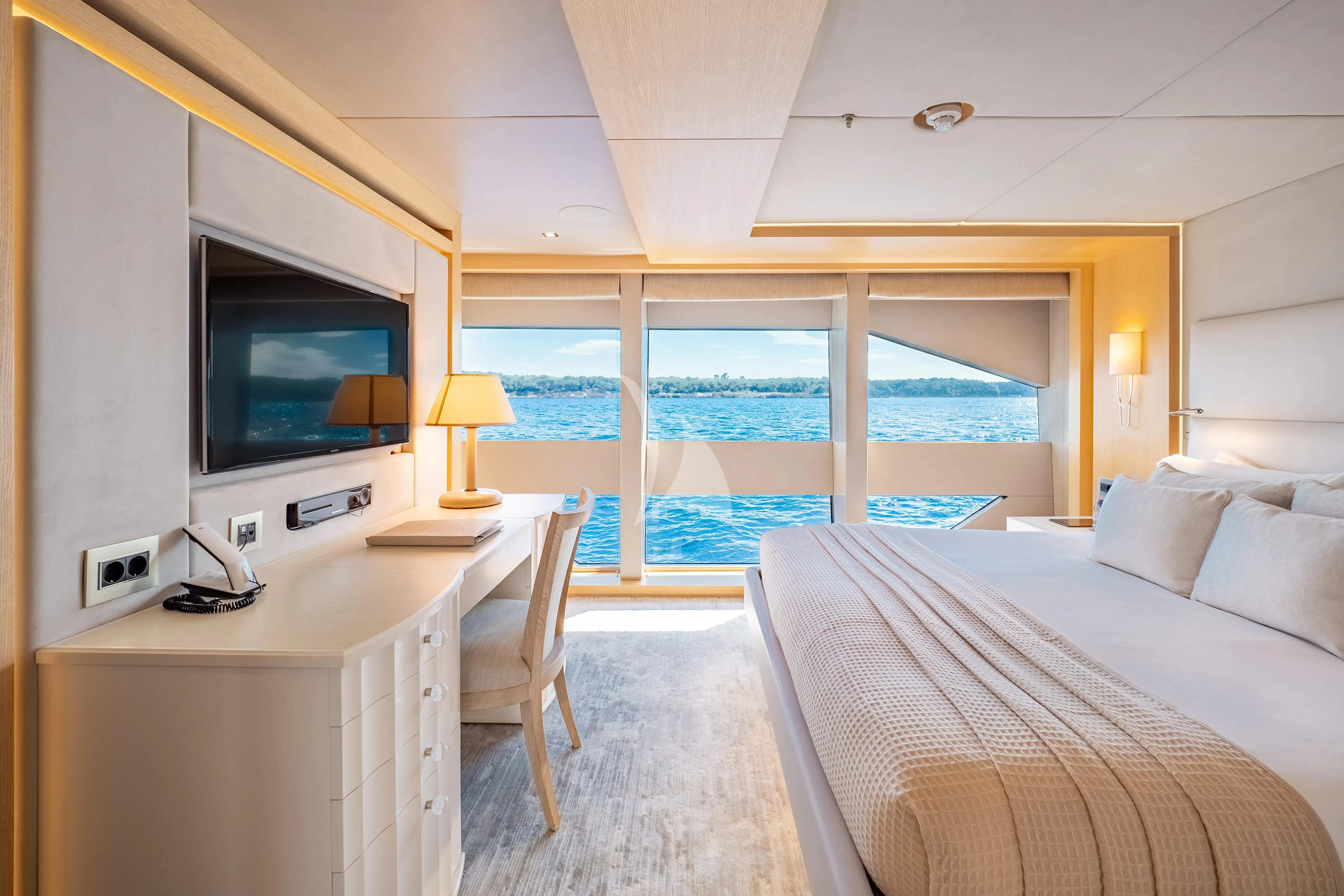 a bedroom with a large flat screen tv and a balcony aboard ARADOS Yacht for Charter