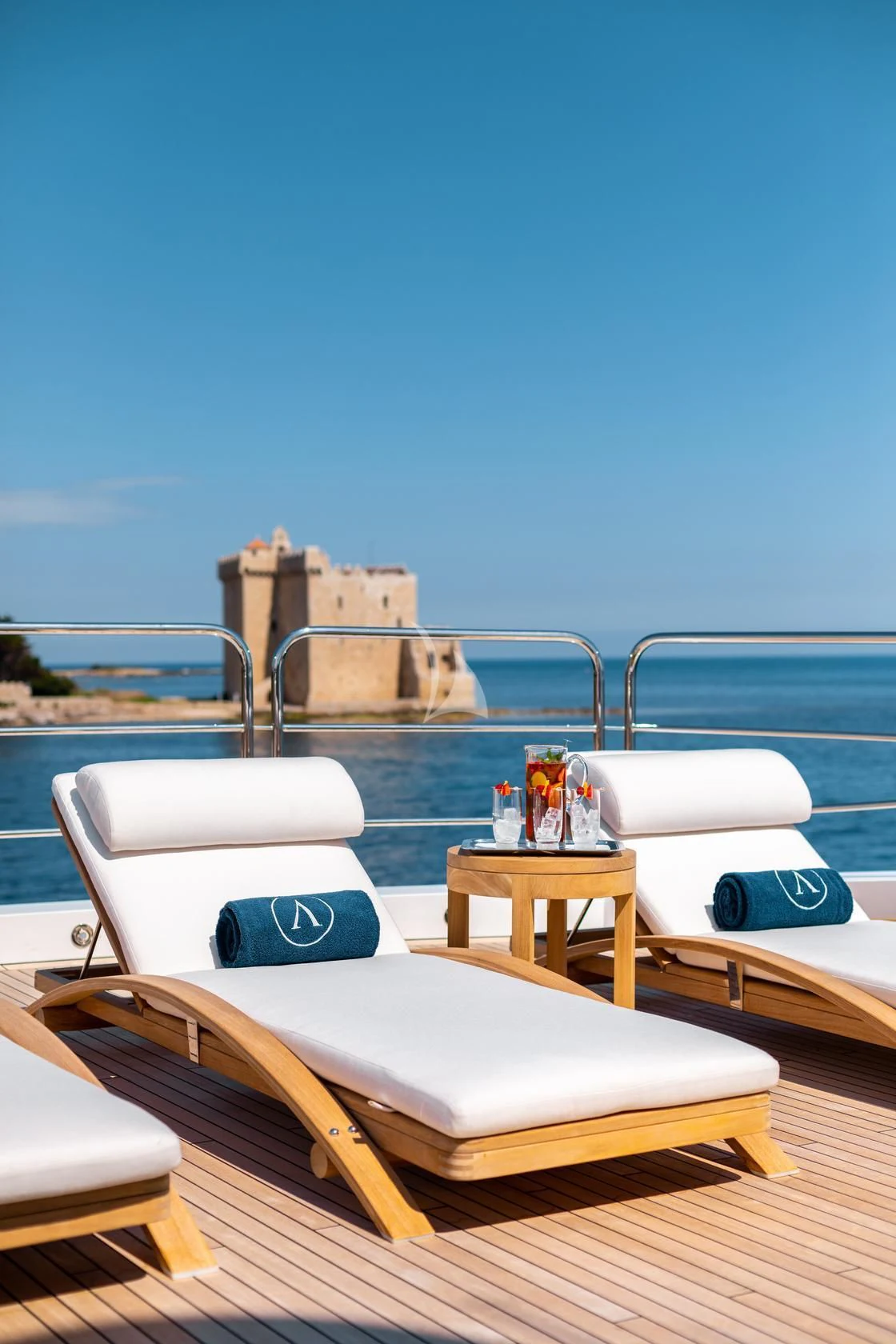 a lounge chair on a deck overlooking a body of water aboard ARADOS Yacht for Charter