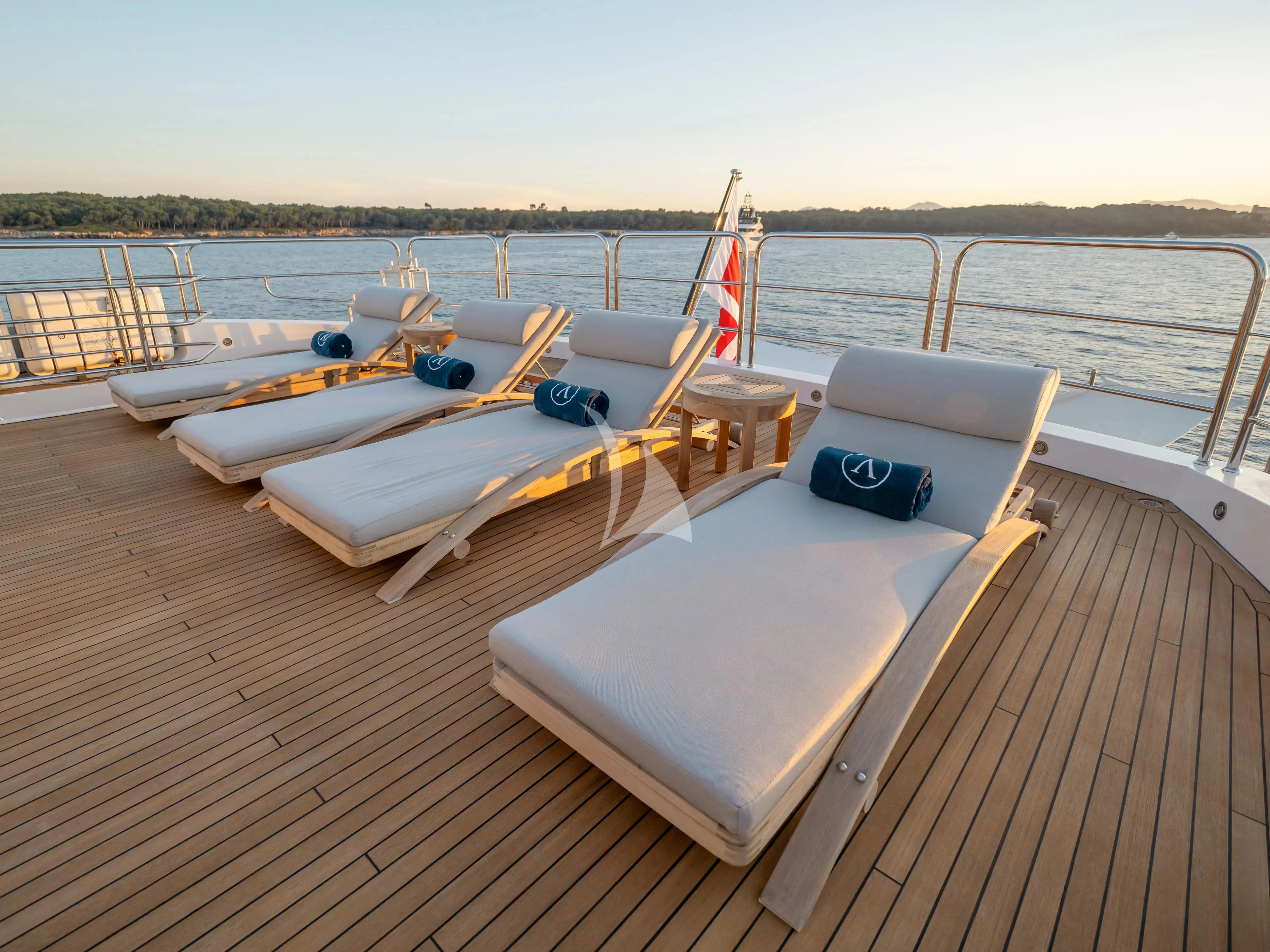 a deck with a boat and a chair on it aboard ARADOS Yacht for Charter