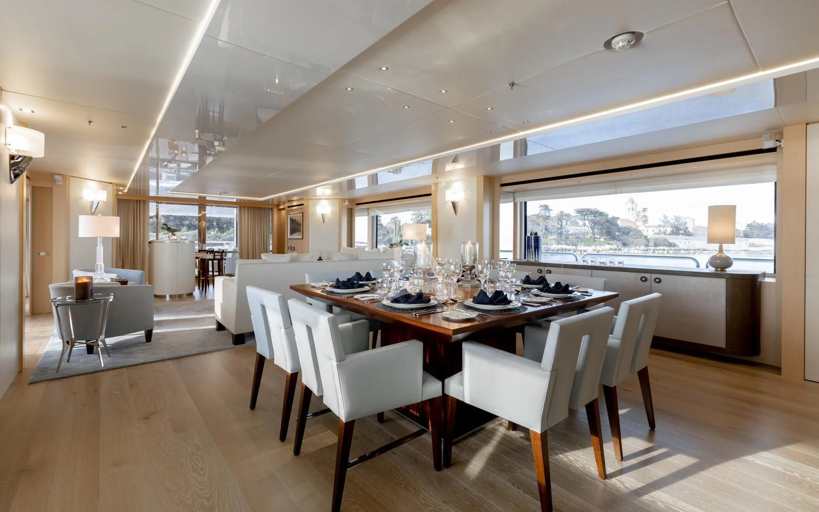 a large dining table in a large room with a large window aboard ARADOS Yacht for Charter