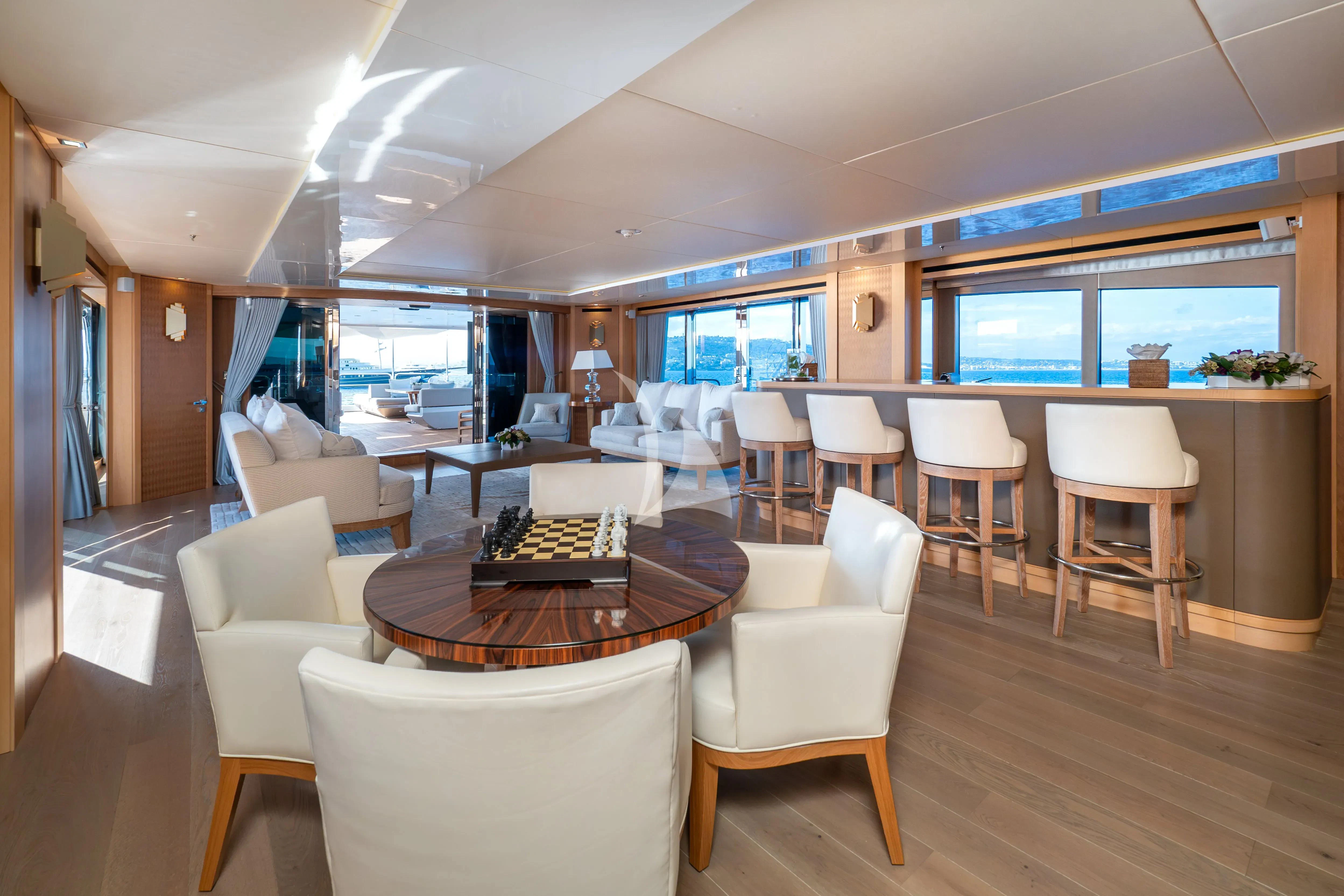 a room with tables chairs and a large window aboard ARADOS Yacht for Charter