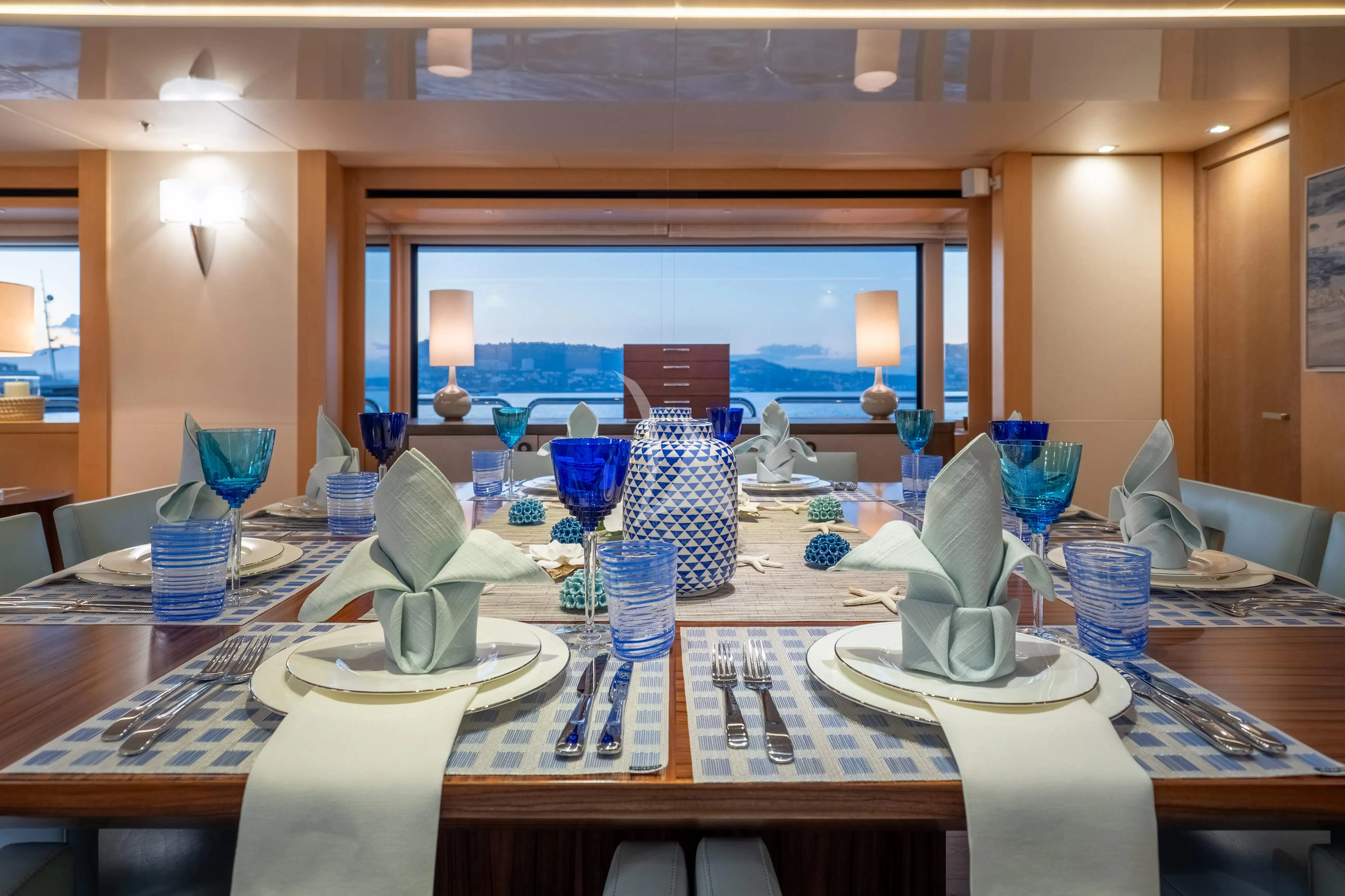 a table with plates and glasses aboard ARADOS Yacht for Charter