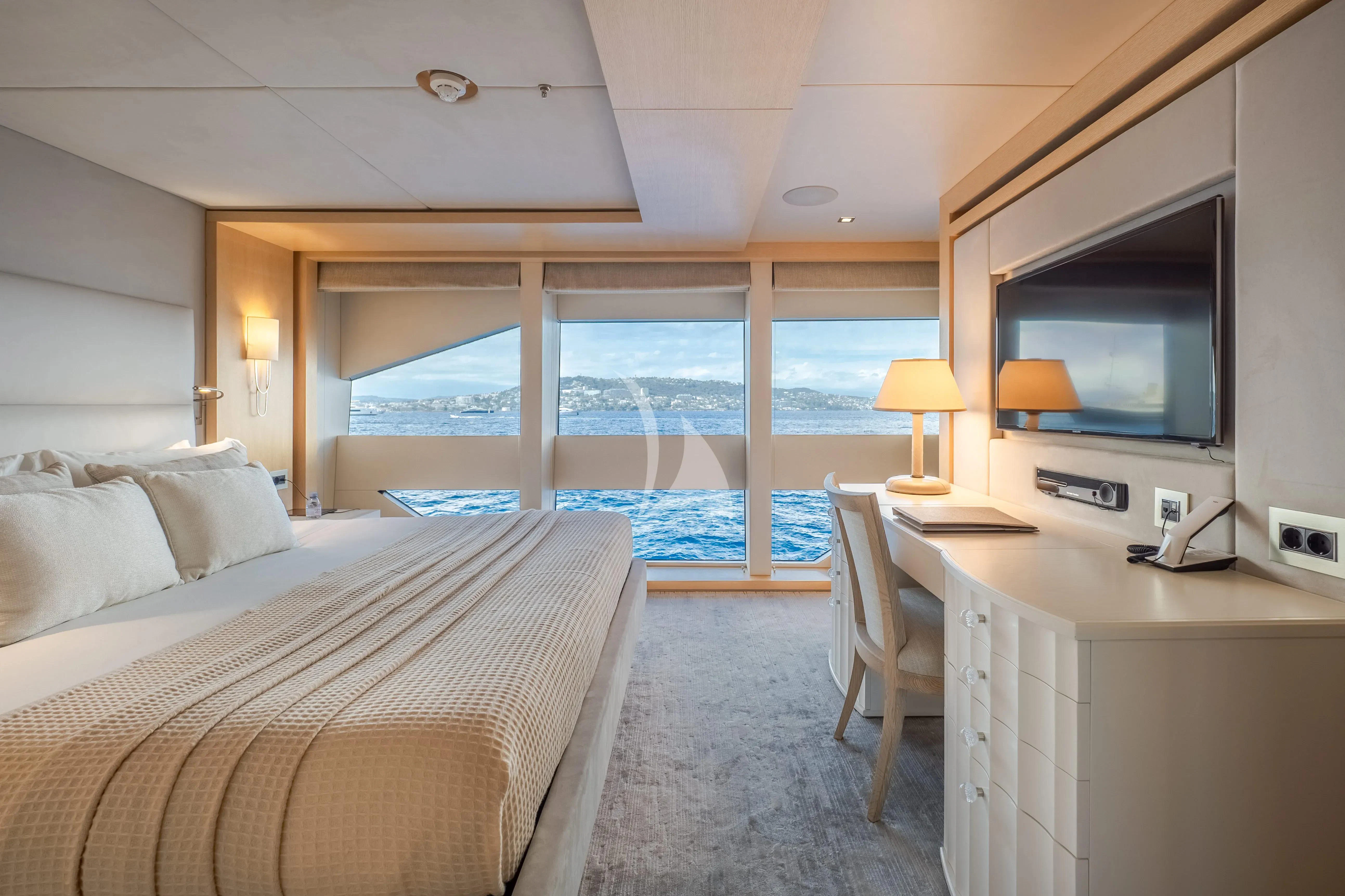 a bedroom with a large bed and a tv aboard ARADOS Yacht for Charter