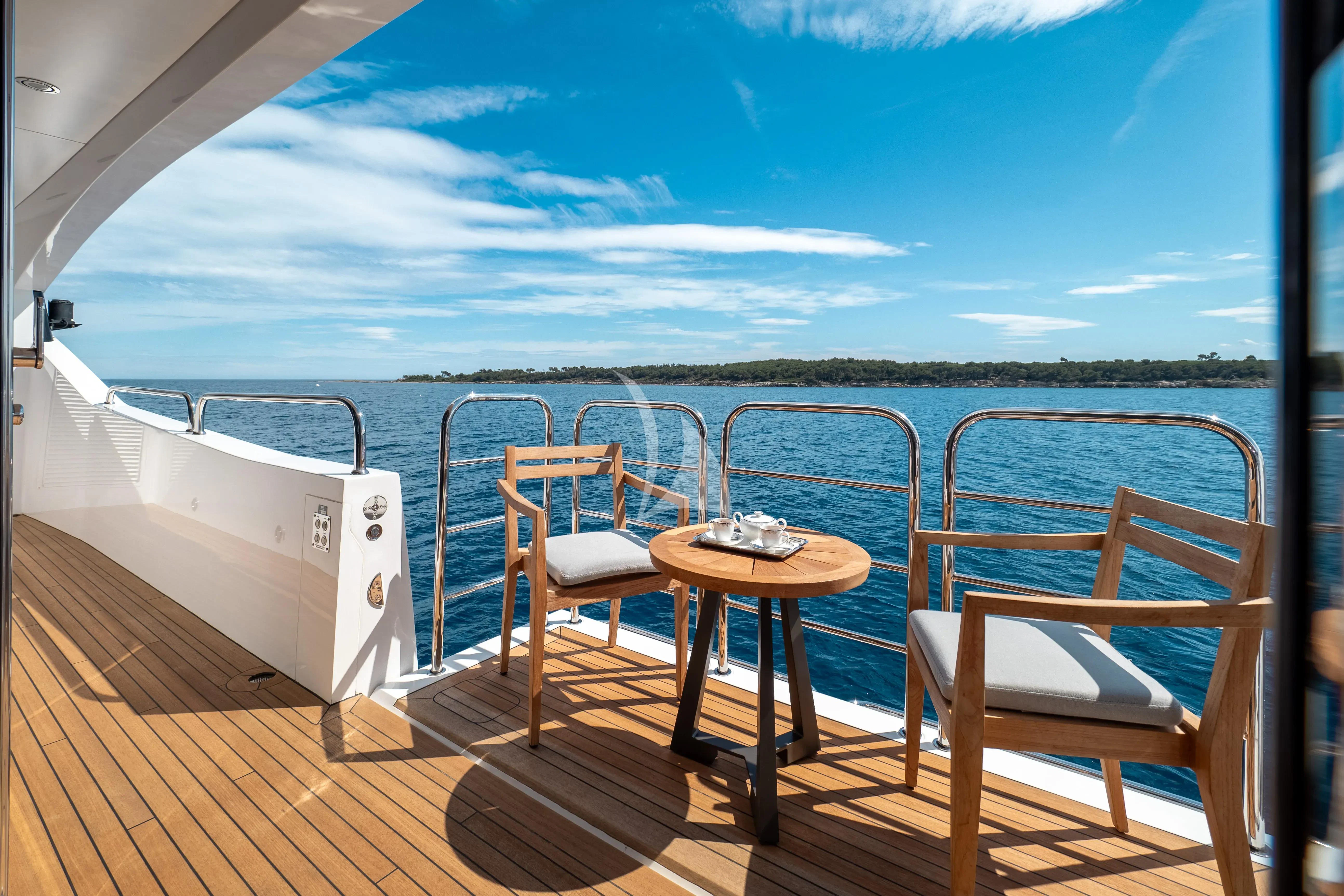 a deck with chairs and a table on it aboard ARADOS Yacht for Charter