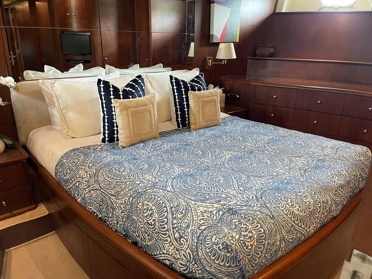 a bed with blue and white sheets aboard REFLECTION Yacht for Sale
