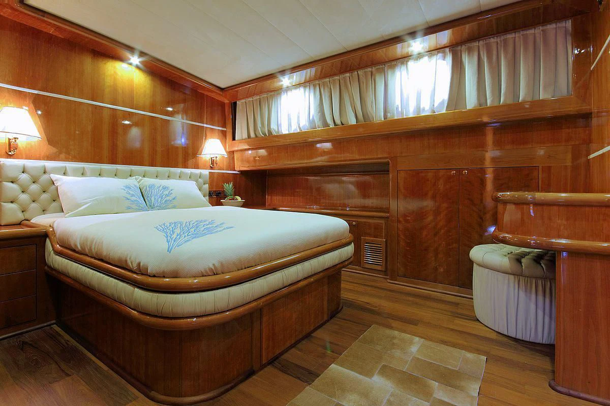 a bedroom with a bed and a chair aboard SILVER MOON Yacht for Sale