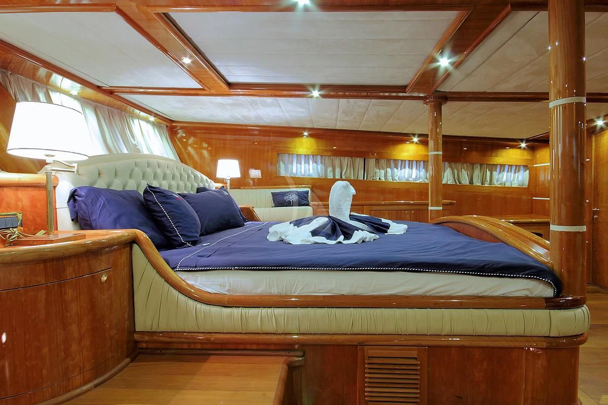 a bed with blue sheets aboard SILVER MOON Yacht for Sale