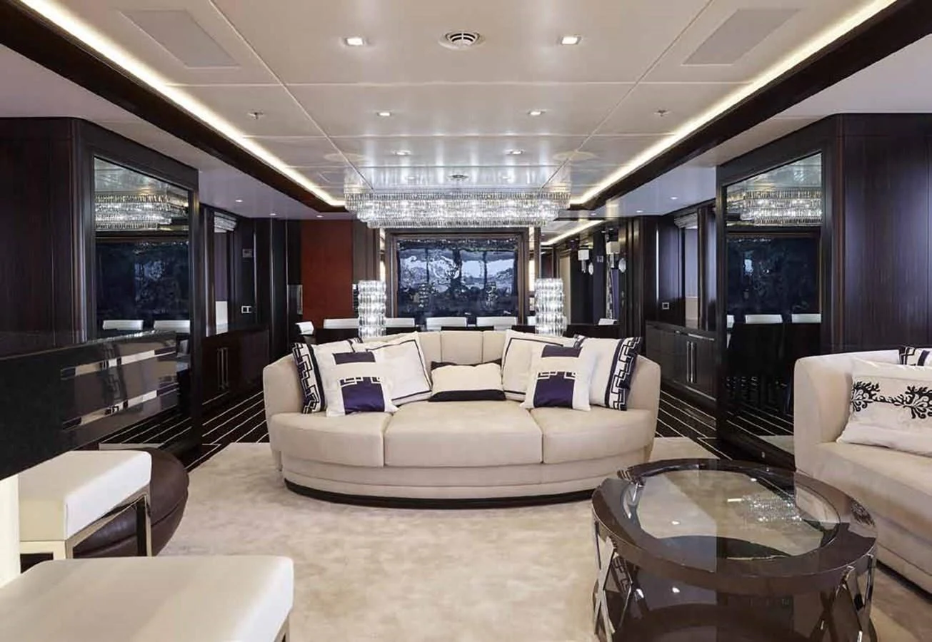 a living room with a large white couch and a large window aboard JULIA Yacht for Sale