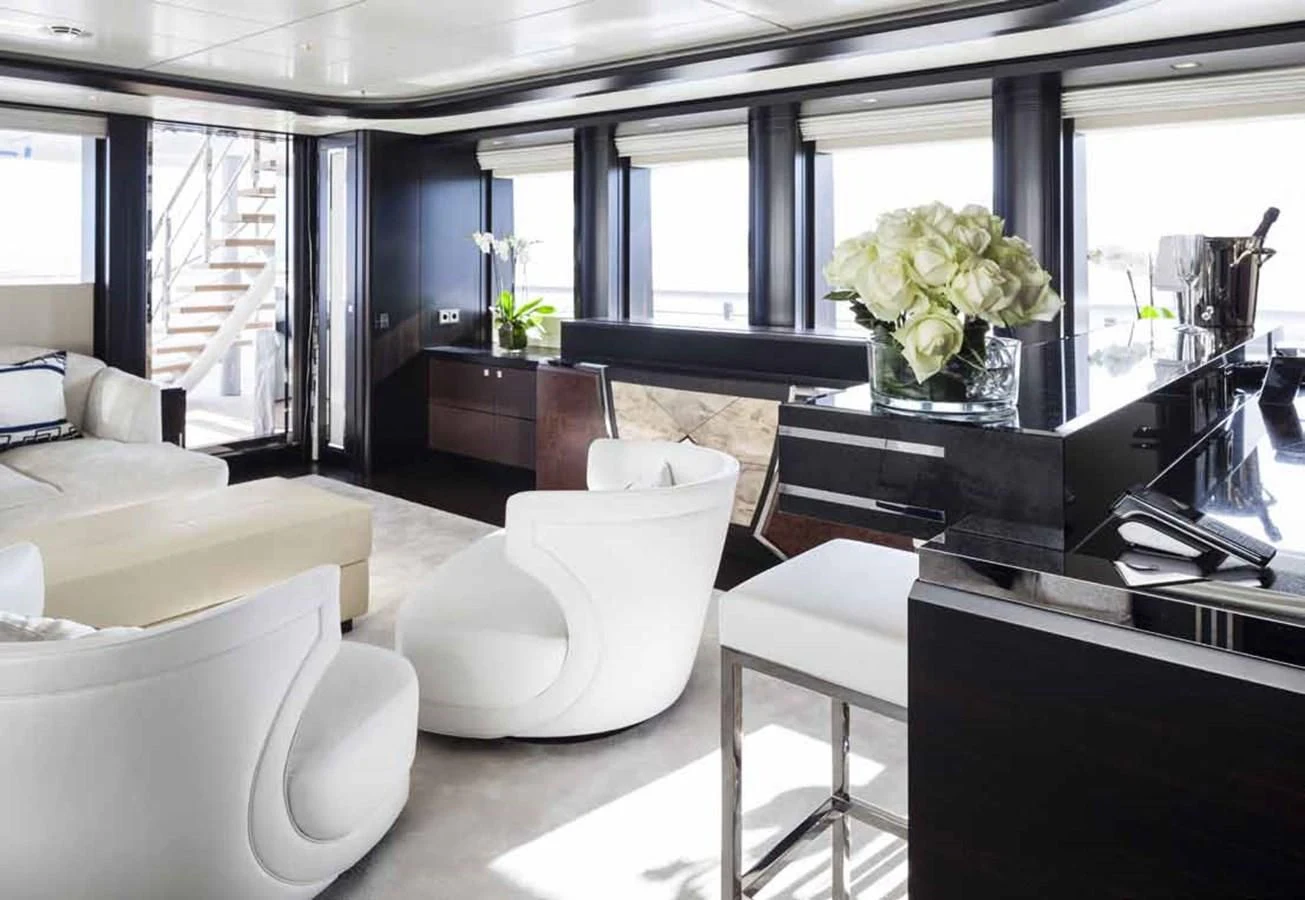 a room with white chairs and a table with flowers on it aboard JULIA Yacht for Sale