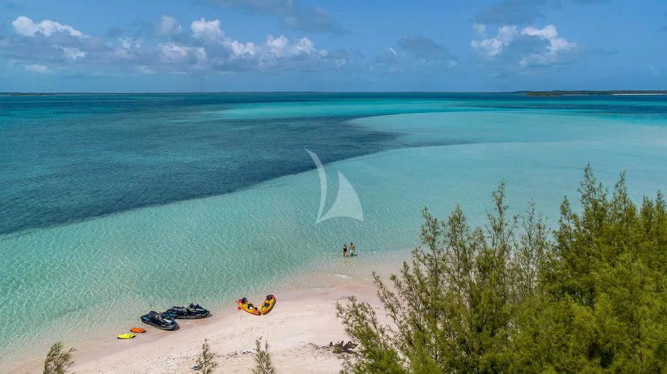 a beach with people and vehicles aboard SILVER LINING Yacht for Sale