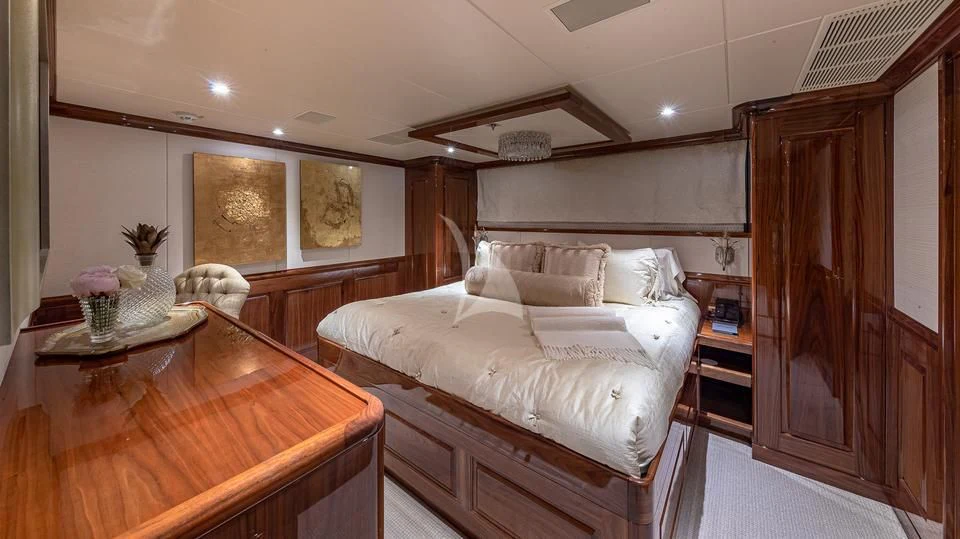 a bedroom with a bed and a table aboard SILVER LINING Yacht for Sale