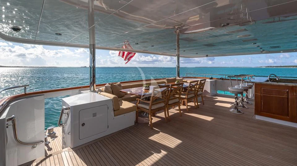 a deck with chairs and a table aboard SILVER LINING Yacht for Sale