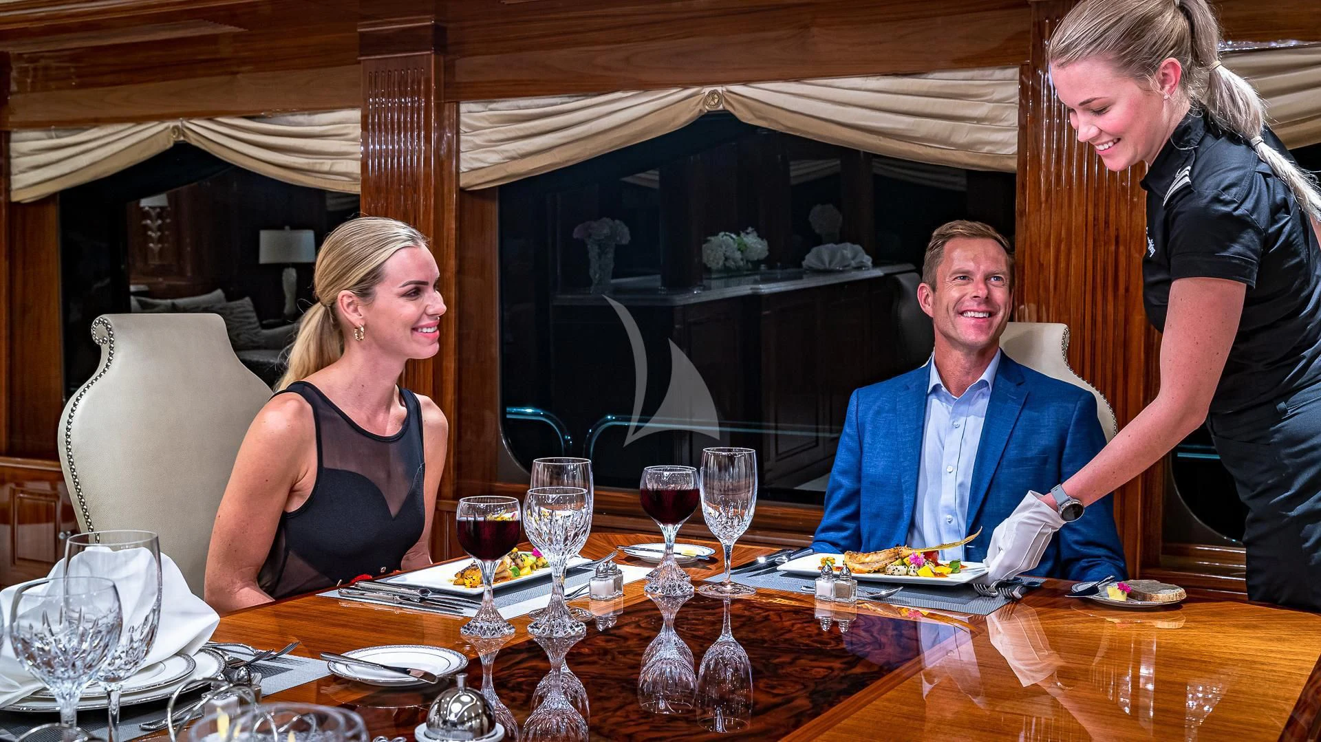a group of people sitting at a table with food and drinks aboard SILVER LINING Yacht for Sale