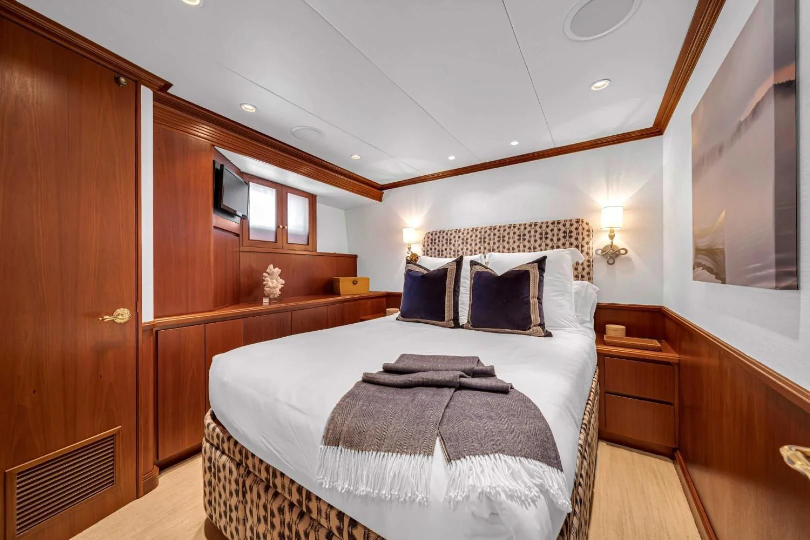 a bedroom with a bed and a wood cabinet aboard CHECKERS Yacht for Sale