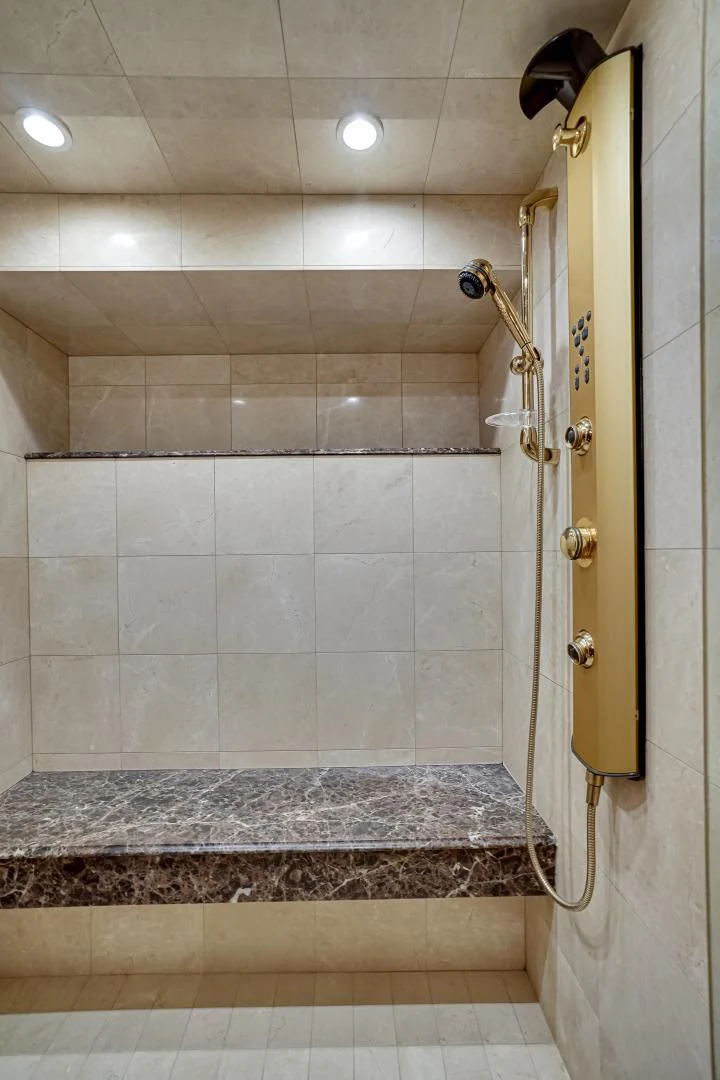 a bathroom with a shower and a marble counter top aboard CHECKERS Yacht for Sale