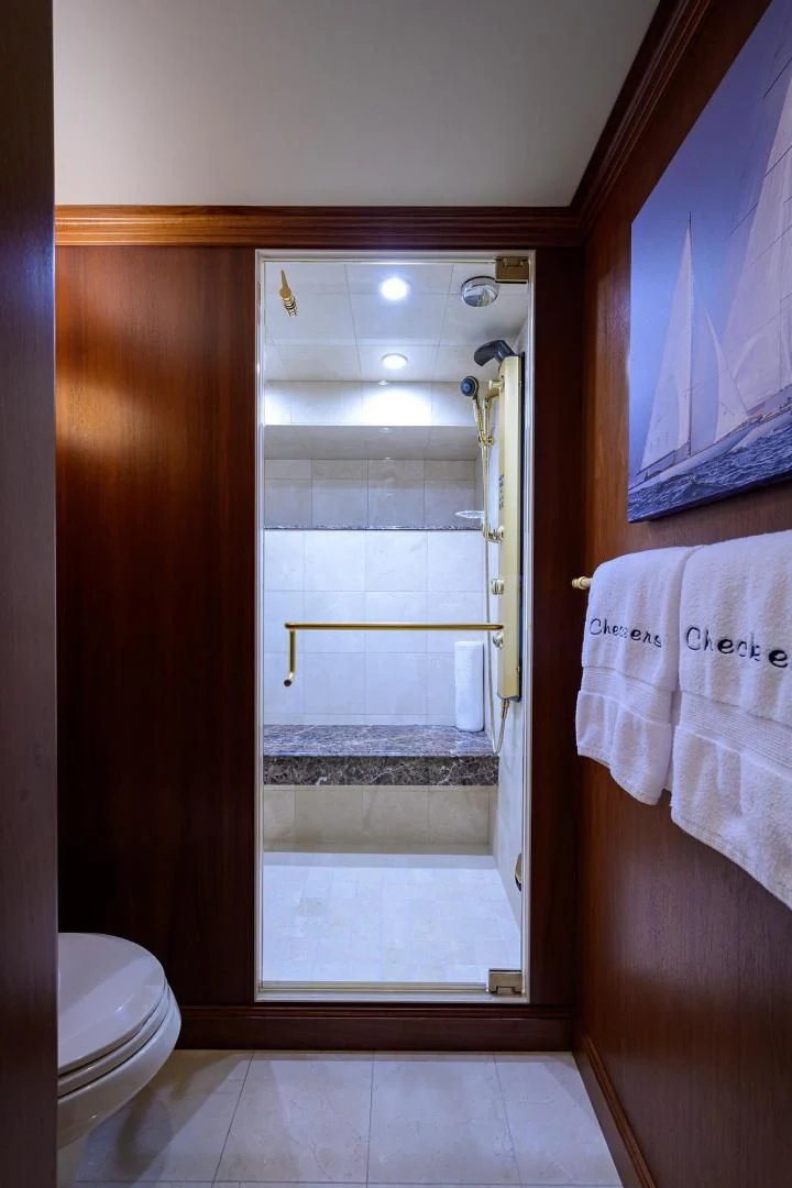 a bathroom with a glass shower door aboard CHECKERS Yacht for Sale