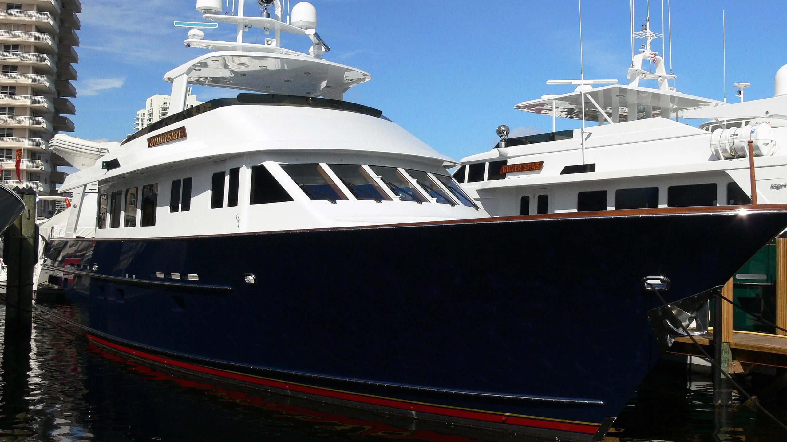 a large white boat in a harbor aboard CHECKERS Yacht for Sale