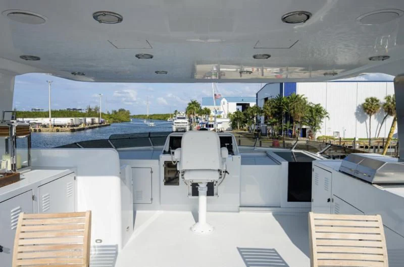 a white chair in a room with a large glass window aboard CHECKERS Yacht for Sale