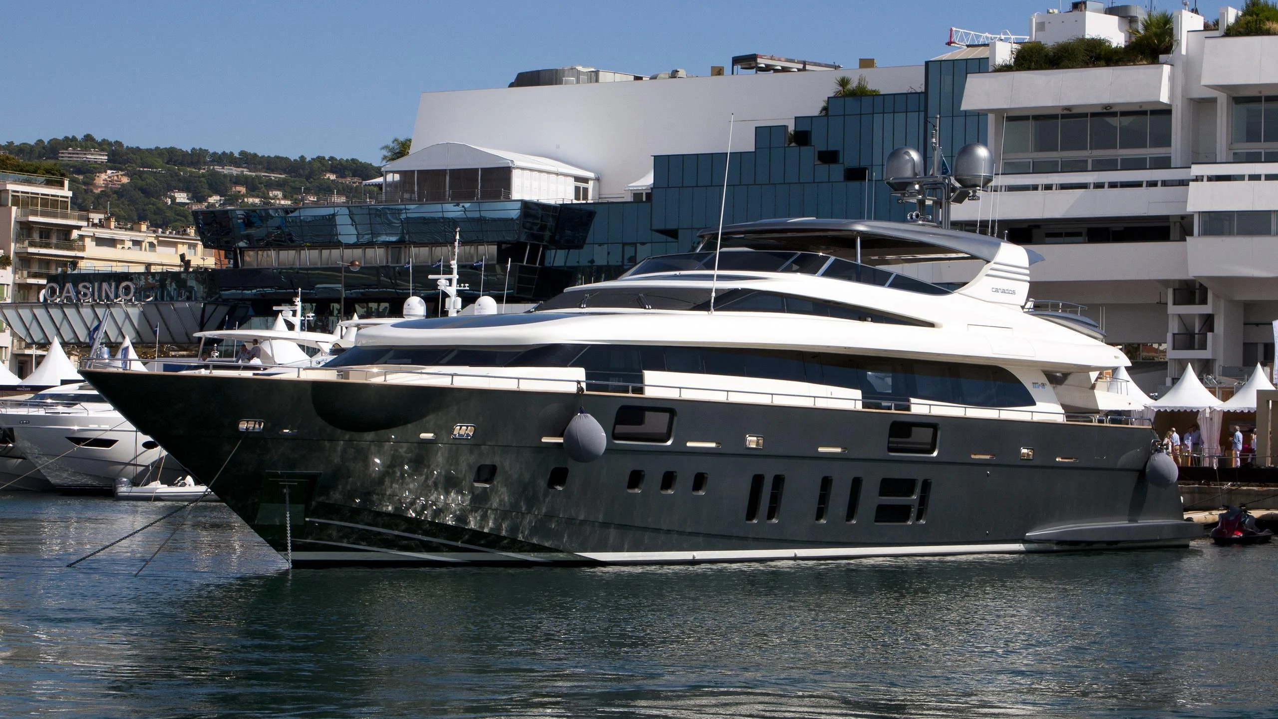a large yacht docked in a harbor aboard M&A'S Yacht for Sale
