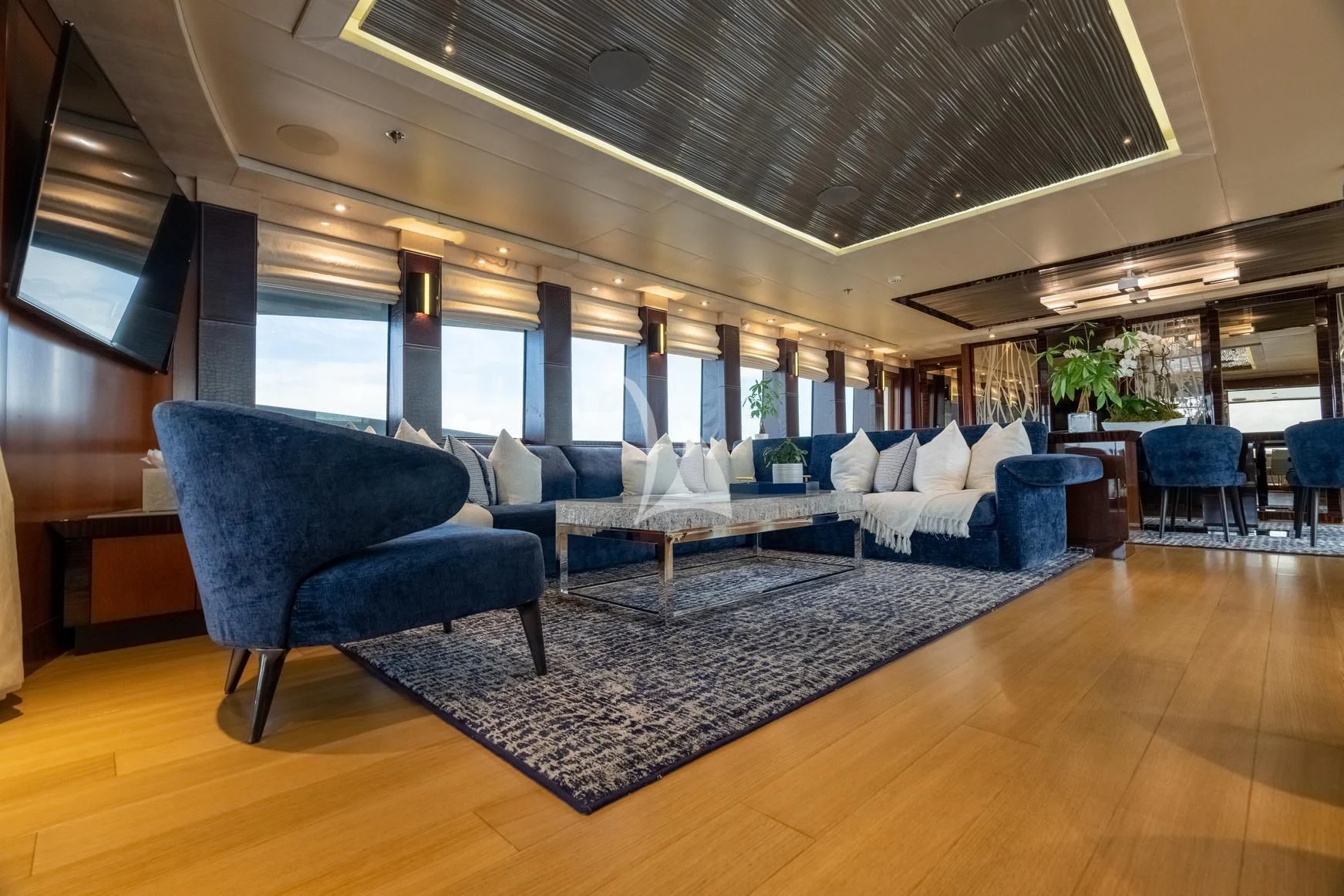 a large living room with a large couch and a large window aboard AQUANOVA Yacht for Sale