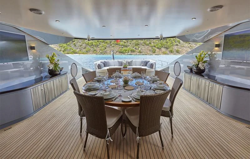 a large dining table with chairs and a large window overlooking a field aboard AQUANOVA Yacht for Sale