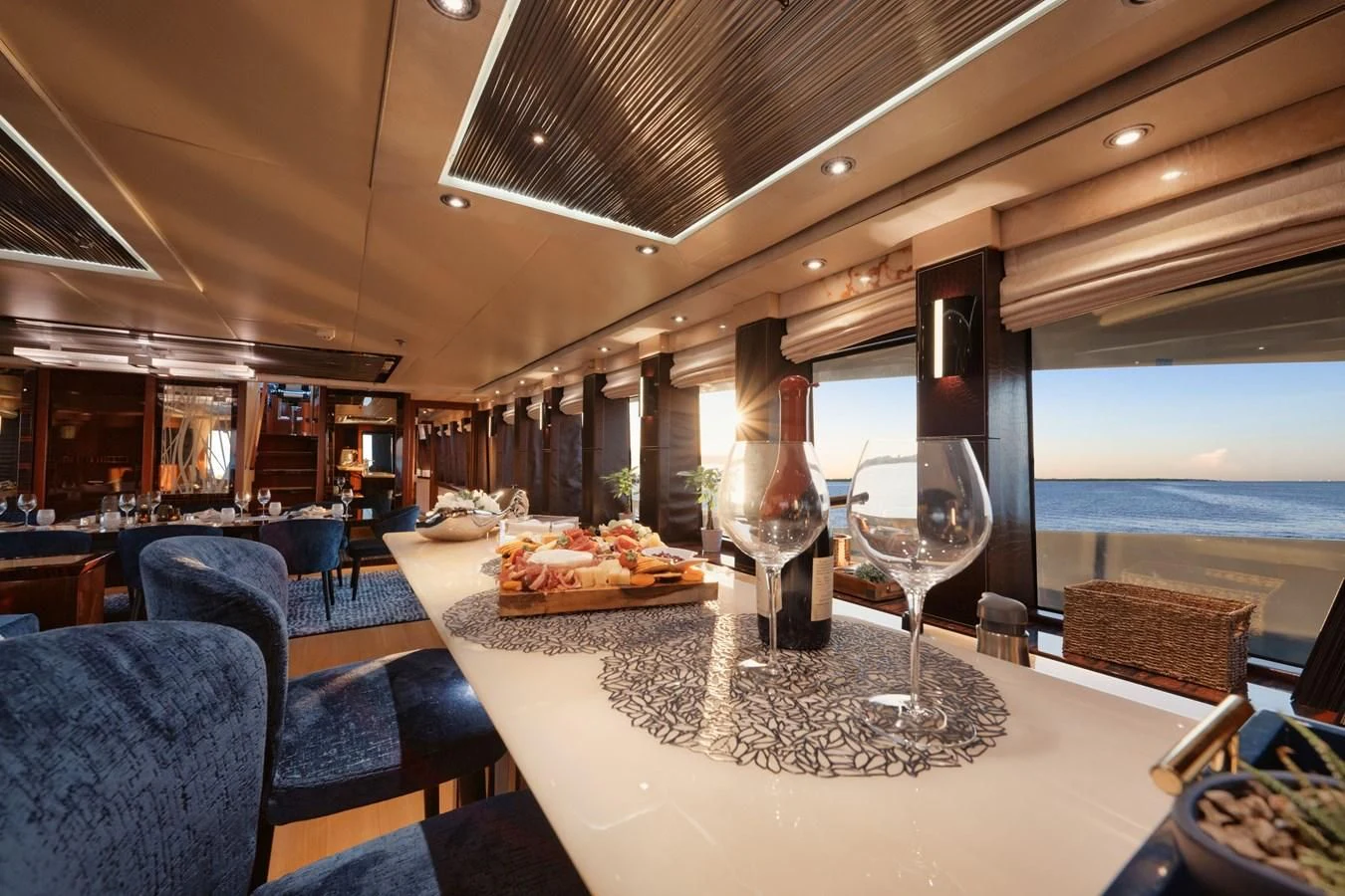 a large room with a table and chairs and a view of the water aboard AQUANOVA Yacht for Sale