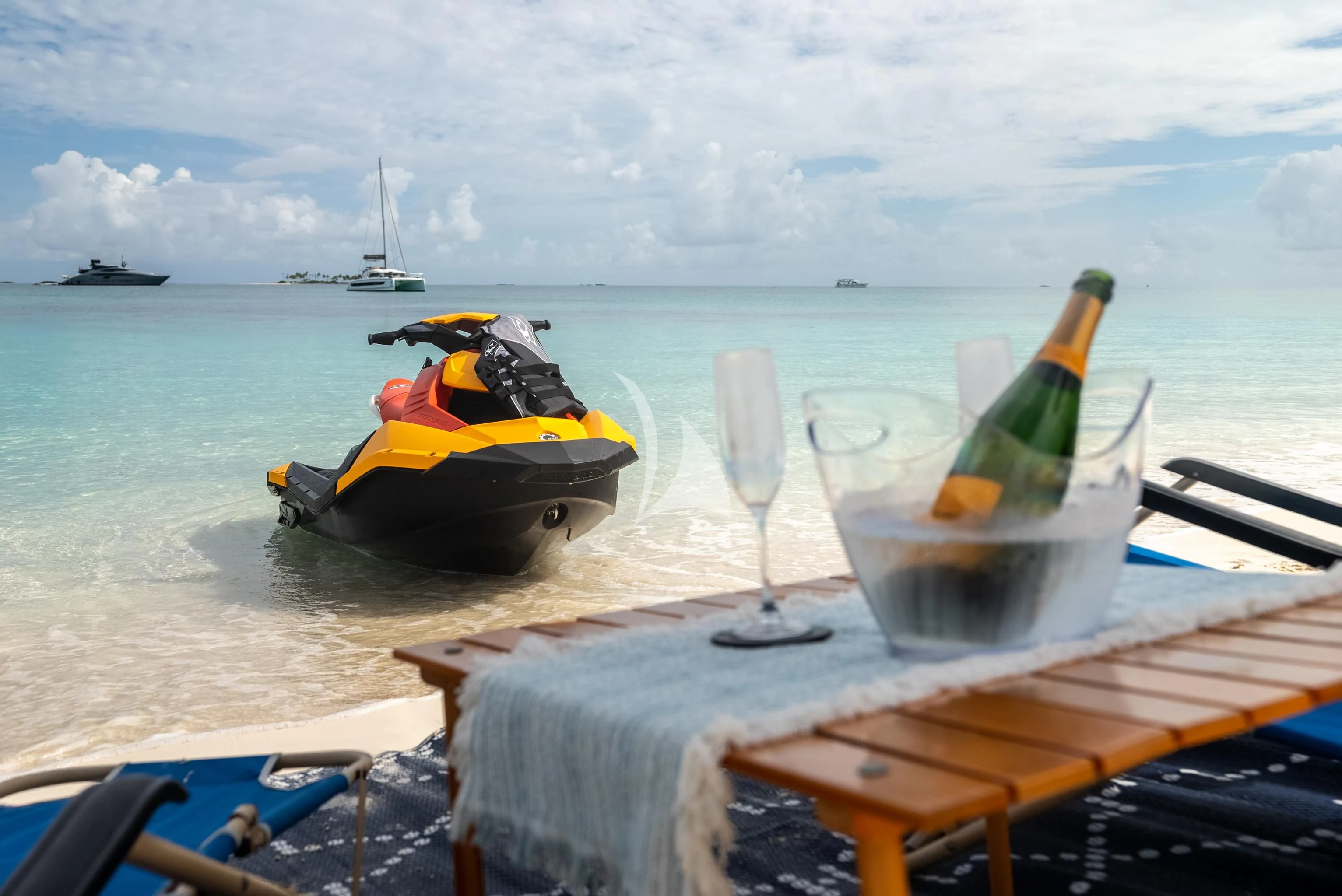 a glass of champagne and a bottle on a table with boats in the water aboard AQUANOVA Yacht for Sale