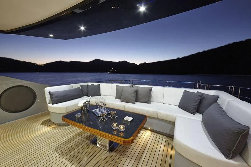 a couch and a table in a room with a view of the water aboard AQUANOVA Yacht for Sale