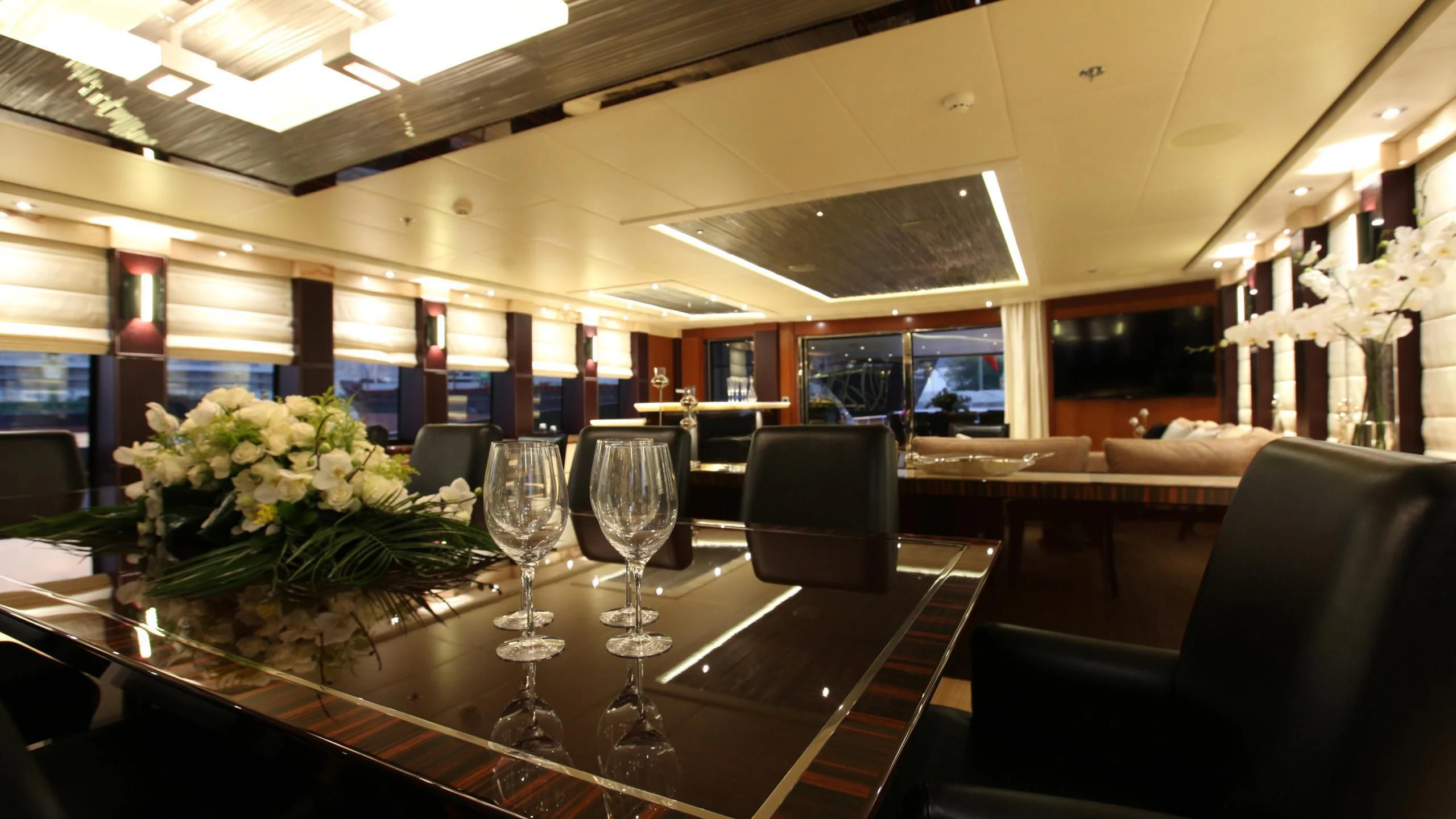 a table with chairs and flowers aboard AQUANOVA Yacht for Sale