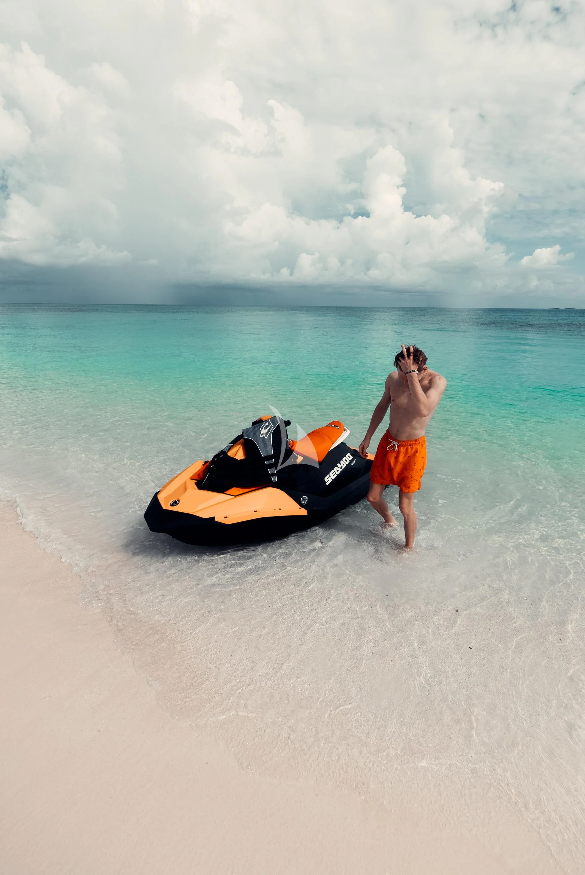 a person standing on a beach next to a speed boat aboard AQUANOVA Yacht for Sale