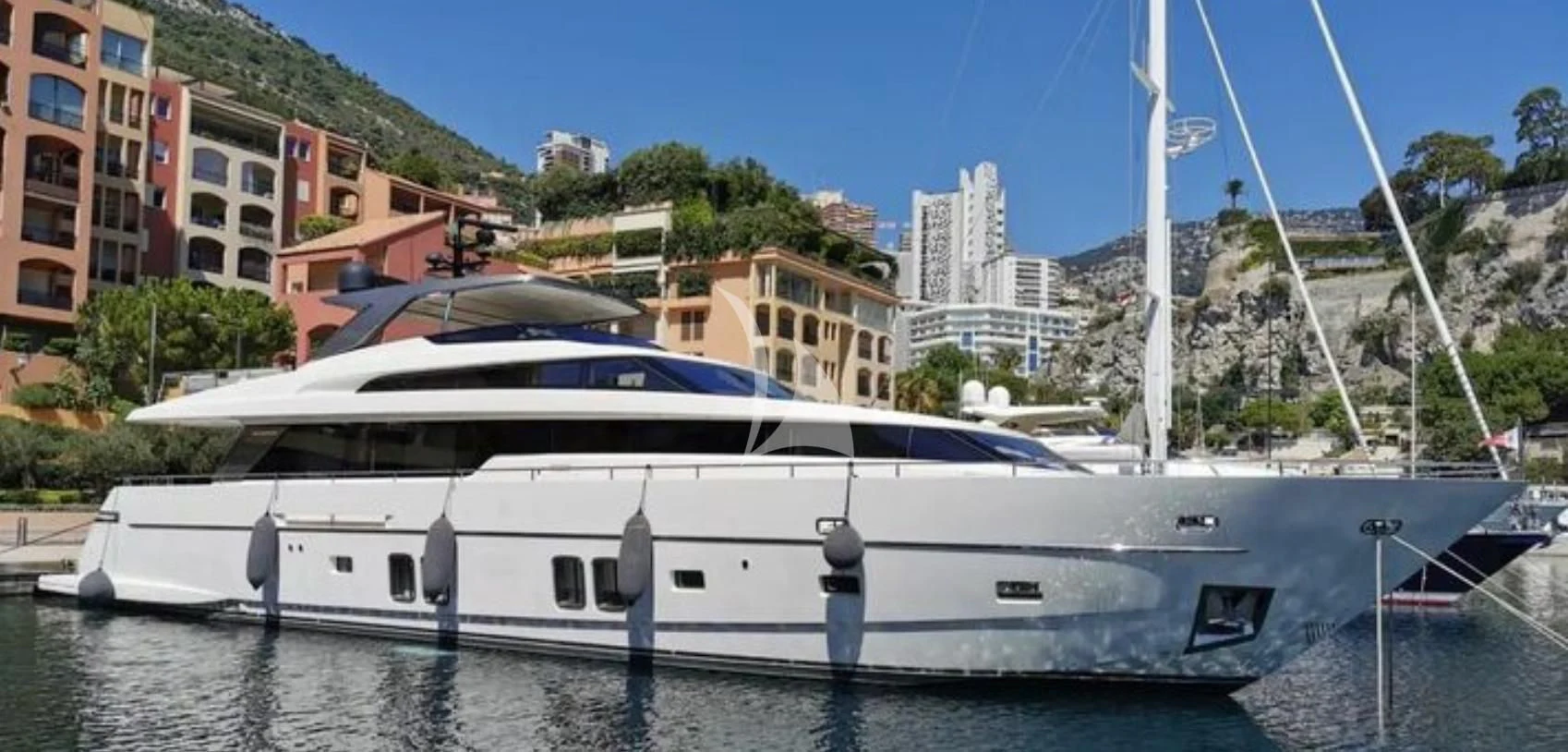 a white yacht in a harbor aboard MUMA Yacht for Sale