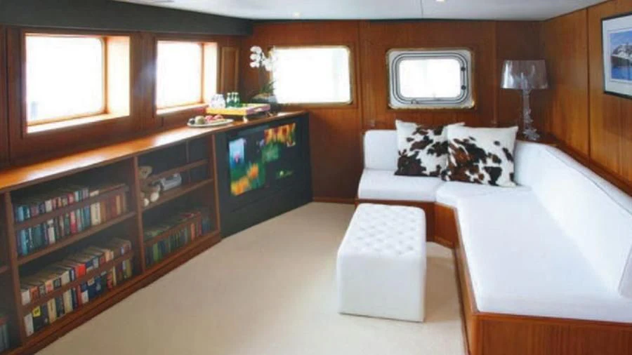 a living room with a couch and a tv aboard OMNIA Yacht for Sale