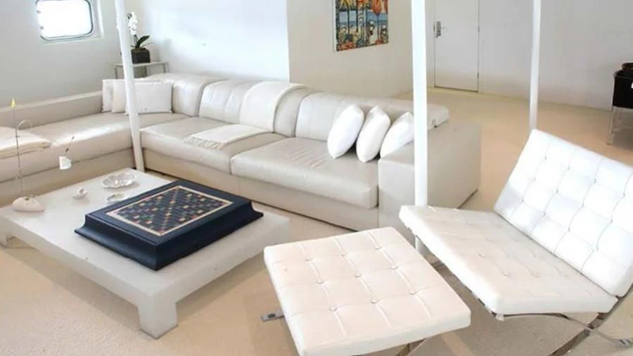 a living room with white furniture aboard OMNIA Yacht for Sale