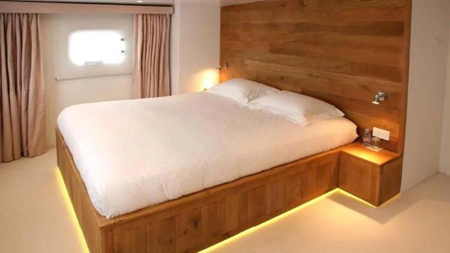 a bed with a white sheet aboard OMNIA Yacht for Sale