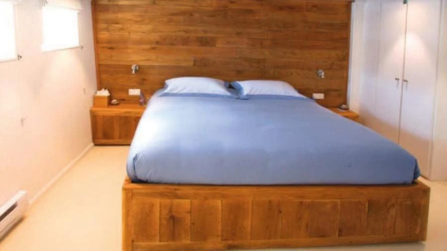 a bed with a blue comforter aboard OMNIA Yacht for Sale