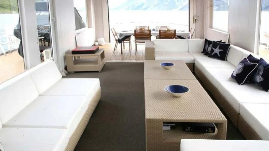 a living room with a couch and a table aboard OMNIA Yacht for Sale