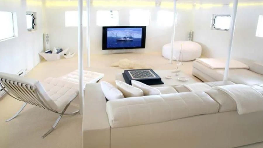 a living room with a couch and a tv aboard OMNIA Yacht for Sale