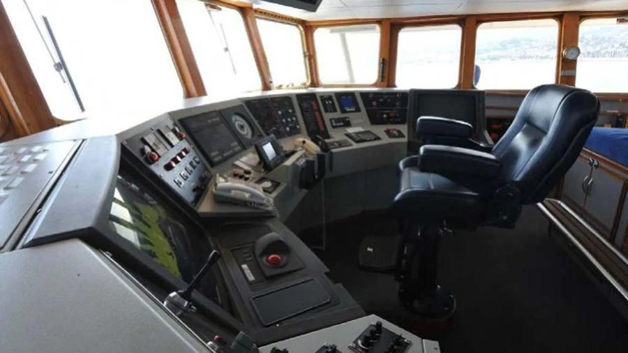 a room with a chair and a desk with computers and a window aboard OMNIA Yacht for Sale