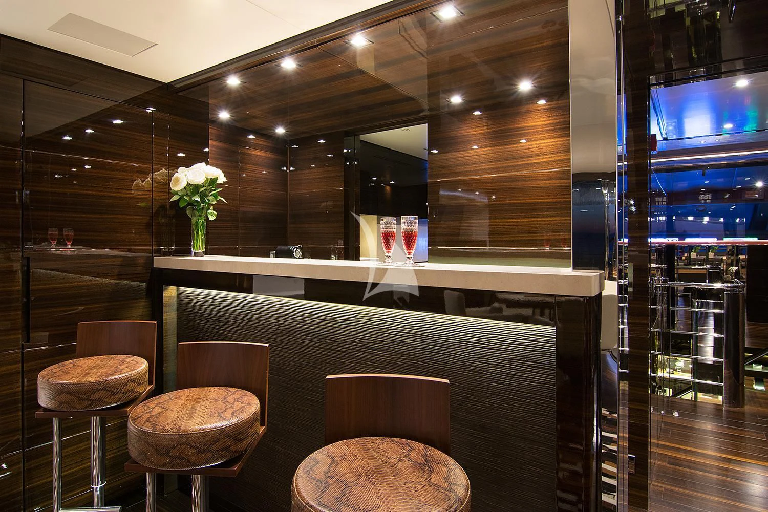 a bar with stools and a table with chairs aboard SOURAYA Yacht for Sale