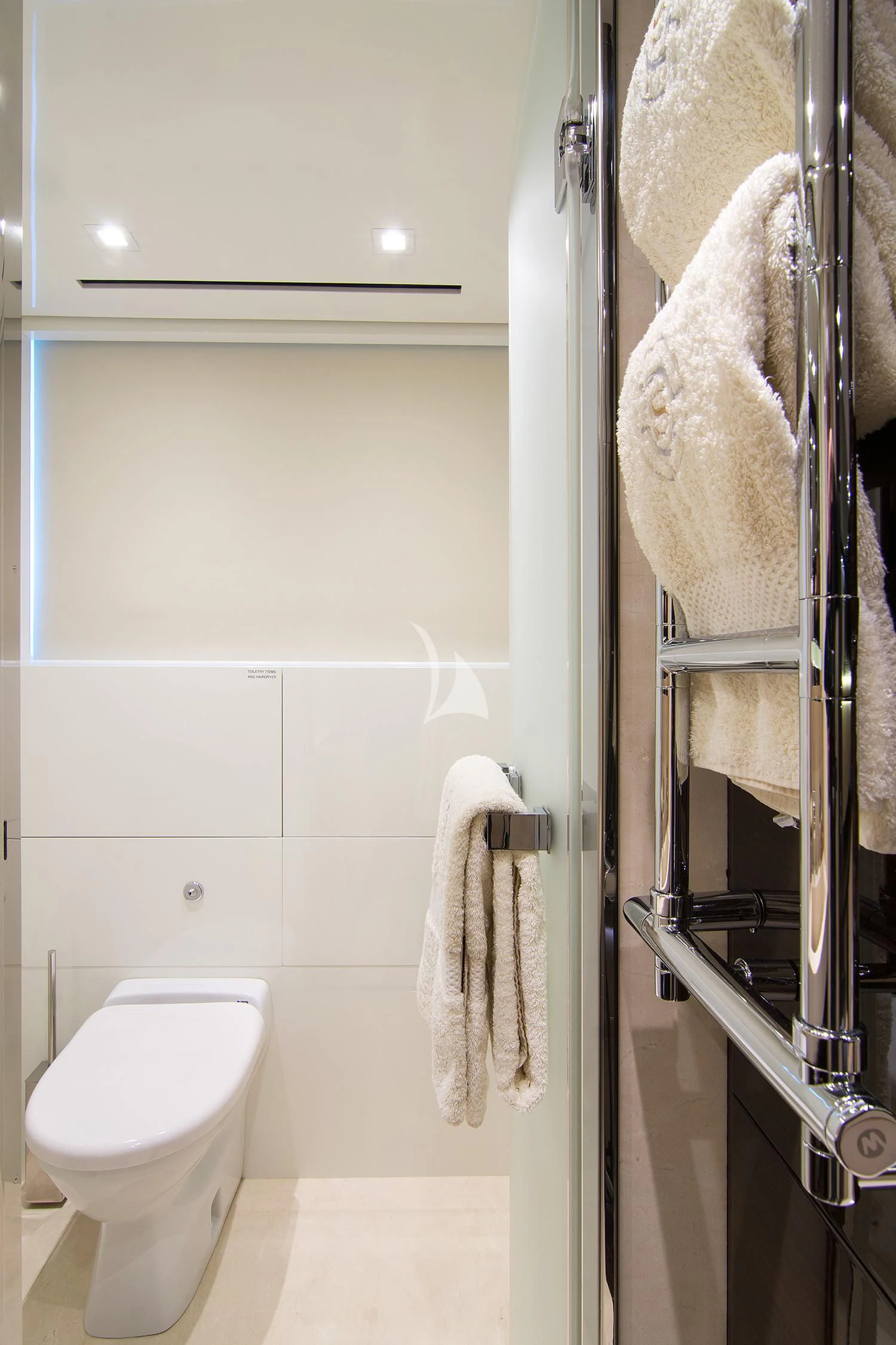 a bathroom with a toilet and a towel on the wall aboard SOURAYA Yacht for Sale