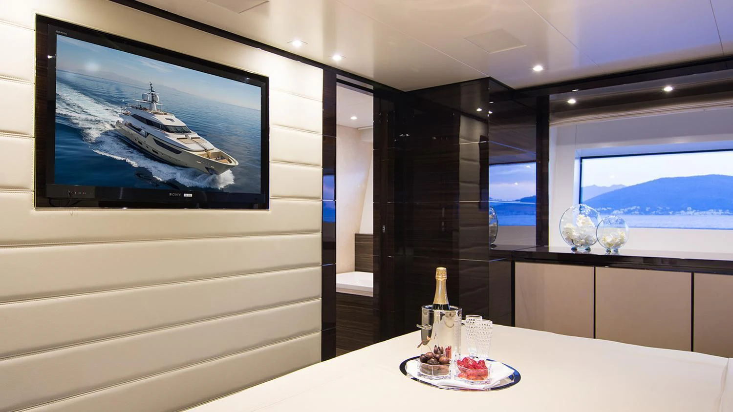 a room with a tv and a table with food and drinks aboard SOURAYA Yacht for Sale