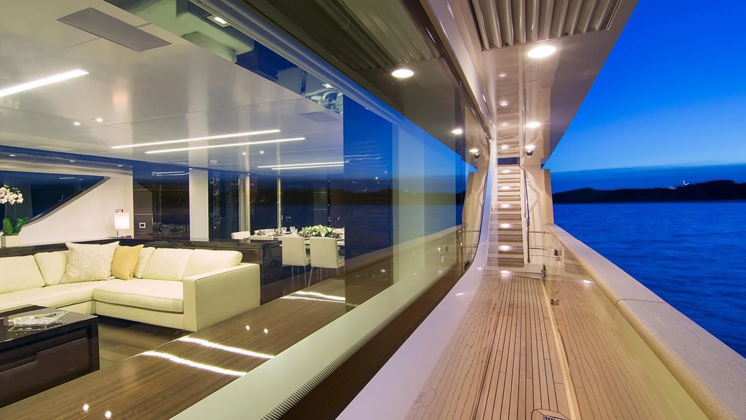 a long wooden dock leading to a large building with a large body of water and a beach and aboard SOURAYA Yacht for Sale