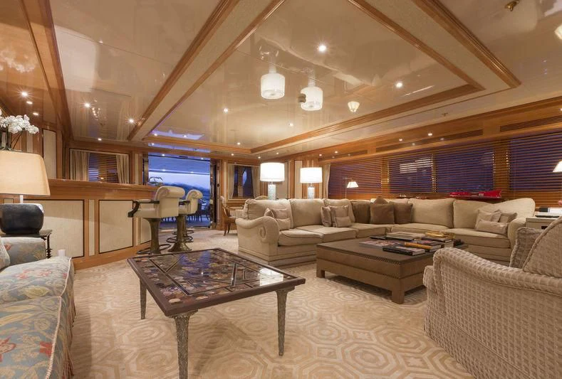 a living room with a large sofa and a coffee table aboard EMERALD (YET) Yacht for Sale